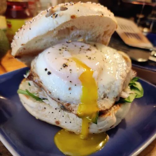 image of a bagel sandwich with a dripping runny egg that Alan made.